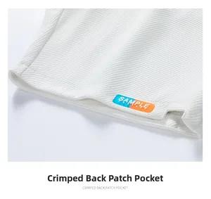 Detail of white textured fabric with back pocket stitching and colorful silicone label