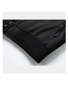 Detail view of black lightweight jacket featuring ribbed knit hem and metal zipper pockets