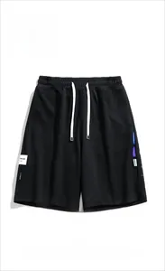 Dettaglio dei pantaloncini sportivi neri con tessuto strutturato e etichette retro street