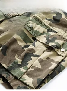 Macro detail of camouflage tactical shorts featuring a 3D cargo pocket with metal snap button