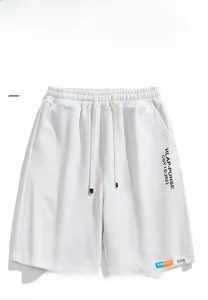 Detail of white waffle knit sports shorts with elastic drawstring waist and logo print