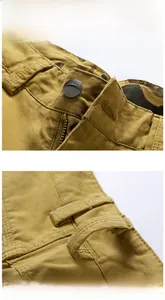 Close-up of metal button with logo and zipper detail on khaki cargo shorts