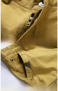 Detailed close-up of metal zipper and reinforced pockets on khaki cotton cargo shorts