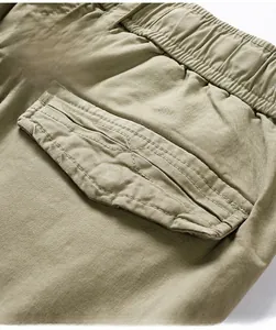 Detail of khaki cargo shorts showing elastic waistband and 3D flap pocket with twill fabric