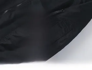 Detail of sleeve pocket on black MA1 flight jacket with iconic red tag accessory
