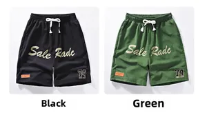 Detail of waist drawstring and Sale Radc graphic on black and green sports shorts