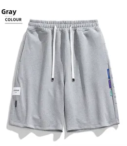 Dettaglio dei pantaloncini grigi casual con coulisse e etichette colorate laterali