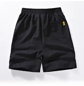 Detail of black quick-dry sports shorts showing elastic waistband and yellow woven pocket label