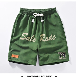 Detail of dark green quick-dry shorts with elastic drawstring waist and NASA graphic prints