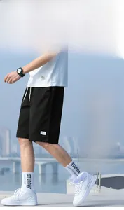 Detail of men's black cargo shorts featuring drawstring waist and double-stitched hem