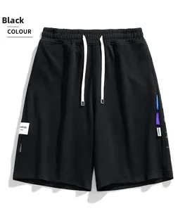 Dettaglio dei pantaloncini sportivi neri con vita elastica e etichette laterali colorate