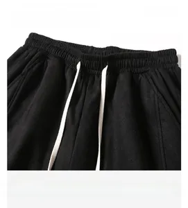 Detail of men's black suede shorts featuring elastic waistband and white drawstring