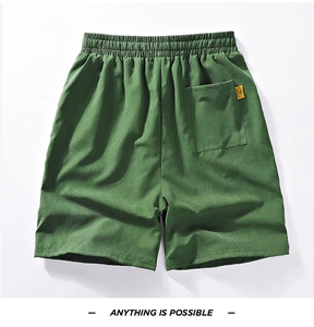 Detail of green quick-dry shorts featuring elastic waistband and back pocket with label