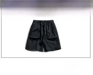 Detail of black ice silk cargo shorts featuring elastic drawstring waist and large pockets