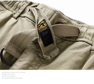 Macro detail of khaki cargo shorts waist with woven belt and metallic D-ring buckle