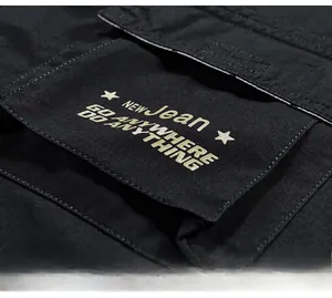 Detailed close-up of rear pocket with yellow print on black cotton cargo shorts