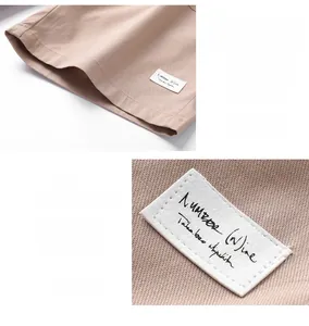 Detail of khaki cotton cargo shorts featuring a stitched brand tag and flat leg cuffs