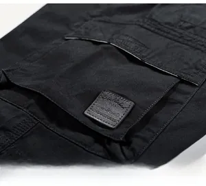 Detail of cargo pocket with double stitching and outdoor wear patch on black cotton shorts