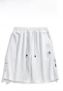 Vue à plat de short en maille blanche avec cordon de serrage et écussons logo