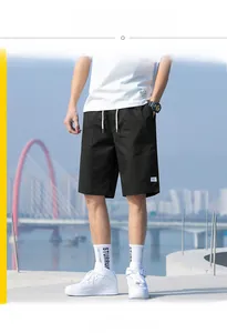 Detail of loose fit black cotton cargo shorts featuring drawstring waist and side pockets