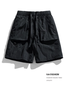 Flat lay of black quick-dry tactical shorts with elastic drawstring waist and cargo pockets