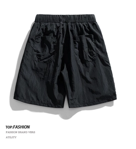 Macro detail of breathable quick-dry fabric and back pockets on black cargo shorts