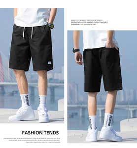 Detailed front and back views of black cotton cargo shorts with a drawstring waist design