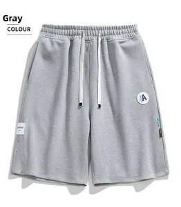 Détail du short décontracté gris avec taille élastique, cordon blanc et écusson latéral