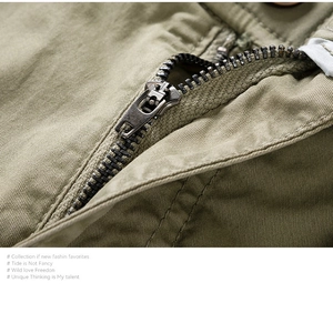 Detail of antique bronze metal zipper on army green cargo shorts with twill texture