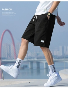 Detail of men's black drawstring cargo shorts styled with white sneakers and crew socks