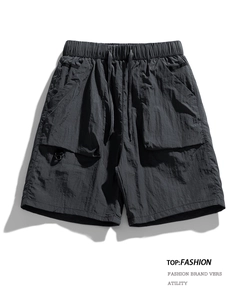 Detailed view of elastic waistband and functional cargo pocket on grey outdoor shorts