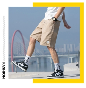 Outdoor close-up of khaki cargo shorts showing cotton twill fabric and white side label