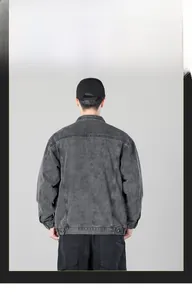 Detail view of the back of a men's washed dark grey denim jacket with dropped shoulders