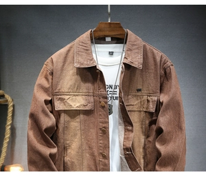 Dettaglio del colletto della giacca di jeans marrone e texture su gruccia in legno