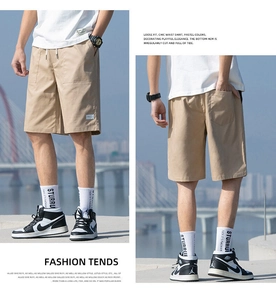 Detail of khaki cotton cargo shorts with drawstring waist and loose fit utility pockets