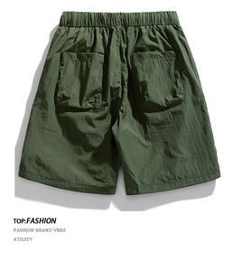 Detail view of dark green cargo shorts with nylon fabric and large functional pockets