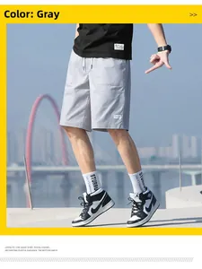 Detail of grey cargo shorts with elastic drawstring waist and woven patch decoration