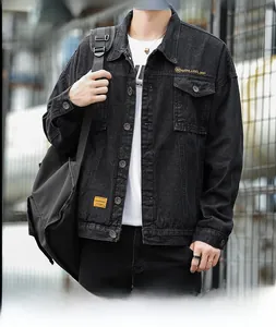 Detail of black denim jacket showing the golden embroidery and metal button texture