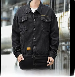 Detail of black denim jacket featuring metallic buttons and yellow letter embroidery