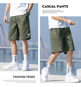Detail of olive green drawstring waist and side cargo pockets on men cotton shorts