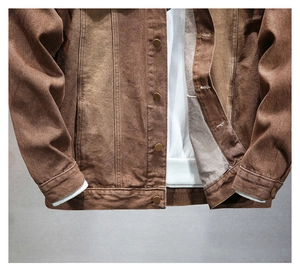 Dettaglio della giacca di jeans marrone lavaggio vintage con bottoni metallici e polsini a coste