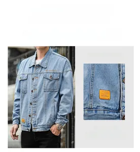 Detail of light blue denim jacket featuring classic chest pockets and orange fashion tag