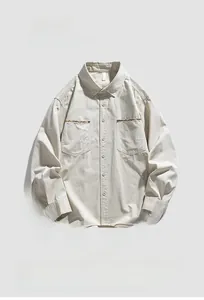 Detail of light beige utility shirt featuring ethnic pattern webbing on chest pockets