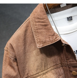 Dettaglio del colletto della giacca di jeans marrone vintage con cuciture e collana