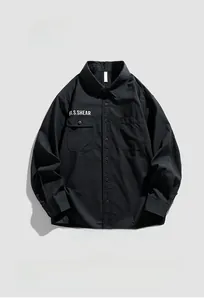 Close-up of black workwear shirt featuring dual chest pockets and white text print