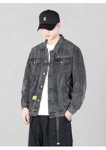 Detailed close-up of grey washed denim jacket with brand embroidery and metal buttons