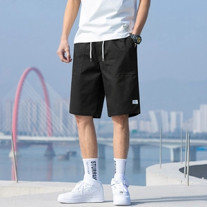 Men's black cotton casual shorts with white drawstring waist on urban outdoor background
