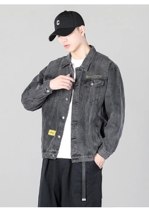 Close-up of dark grey washed denim jacket featuring white embroidery and yellow chest label