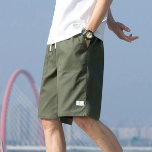 Men's olive green cargo shorts with white drawstring and elastic waist in outdoor setting