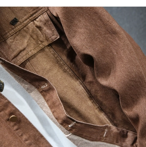 Dettaglio del colletto di una giacca di jeans marrone con targhetta in metallo 1596